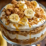 Layered dessert featuring Biscoff Banana Pudding with fresh bananas and cookie butter in a glass bowl