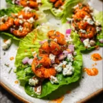 Buffalo shrimp lettuce wrap tacos with ranch, red onion, and celery in crisp romaine