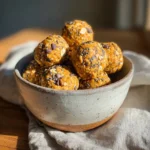 Pumpkin pie energy balls with oats, chia seeds, and chocolate chips in a ceramic bowl