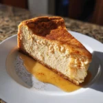 Slice of pumpkin protein cheesecake with cinnamon and syrup on white plate